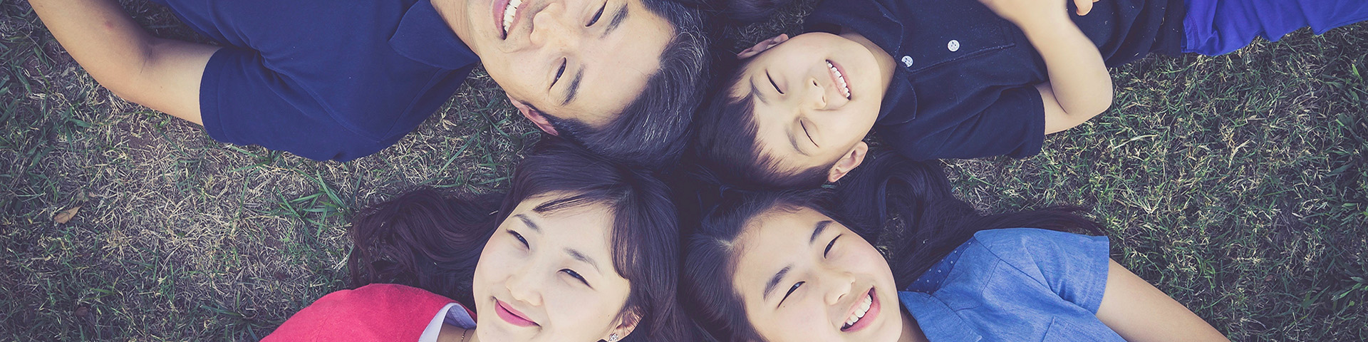 Asian Family laying on grass outdoors